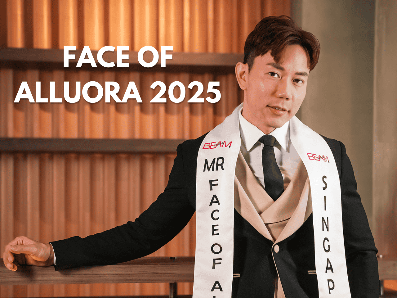 Face of Alluora 2025 promotional event, stylish man wearing sash at modern venue.