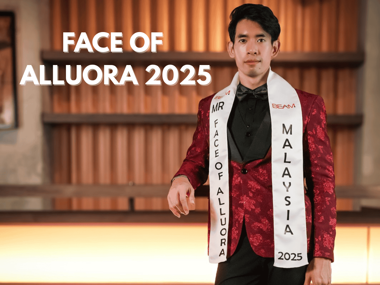 Elegant man in a tuxedo with sash for Face of Alluora 2025, standing confidently in a stylish setting.