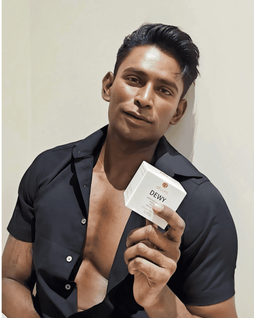 Dewy moisturizer skincare product by alluora, black male model holding skincare box, promoting hydration and healthy skin, promotional skincare image.