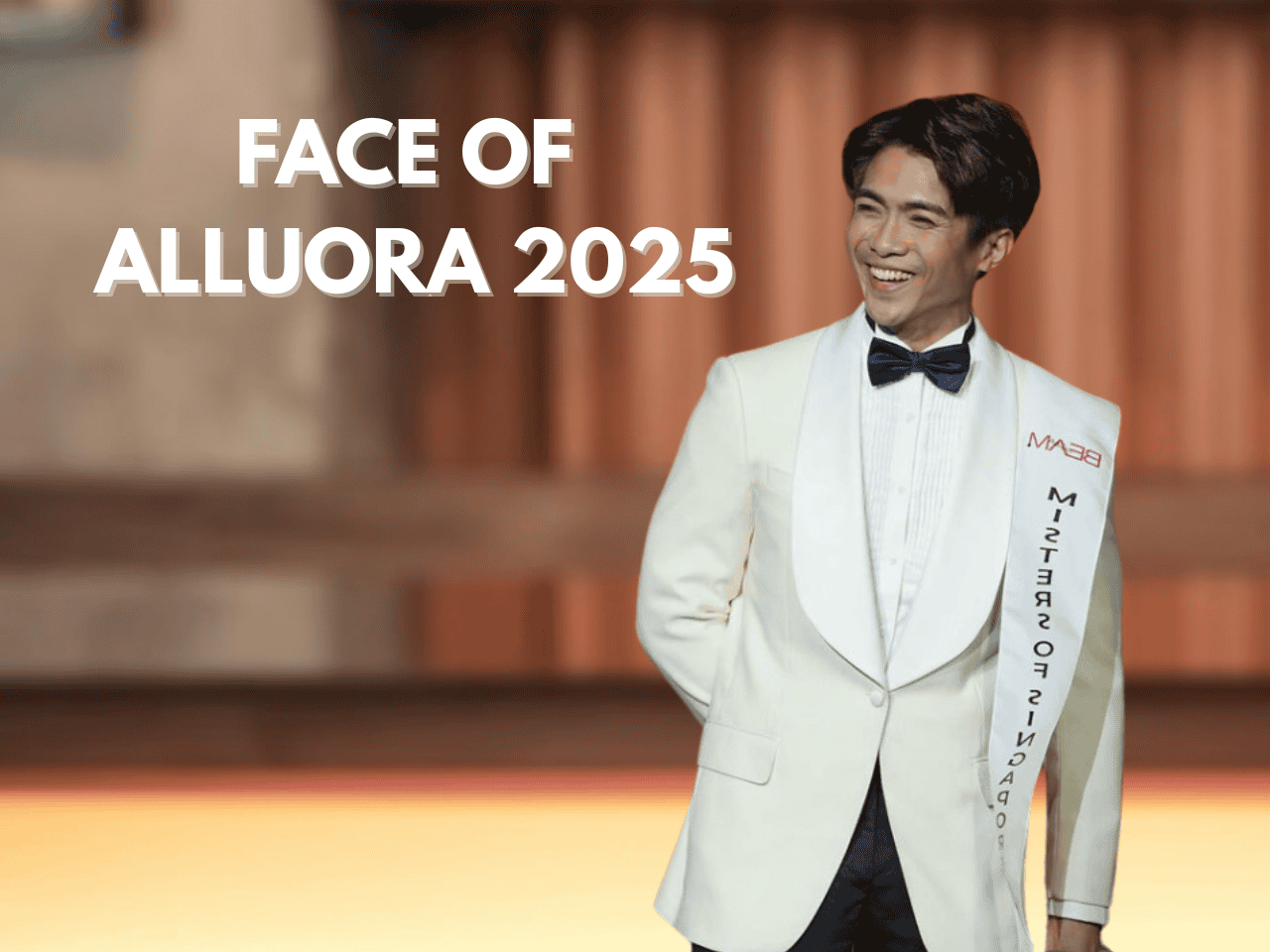 Elegant man in formal white tuxedo with bowtie for Alluora 2025 event, smiling confidently.